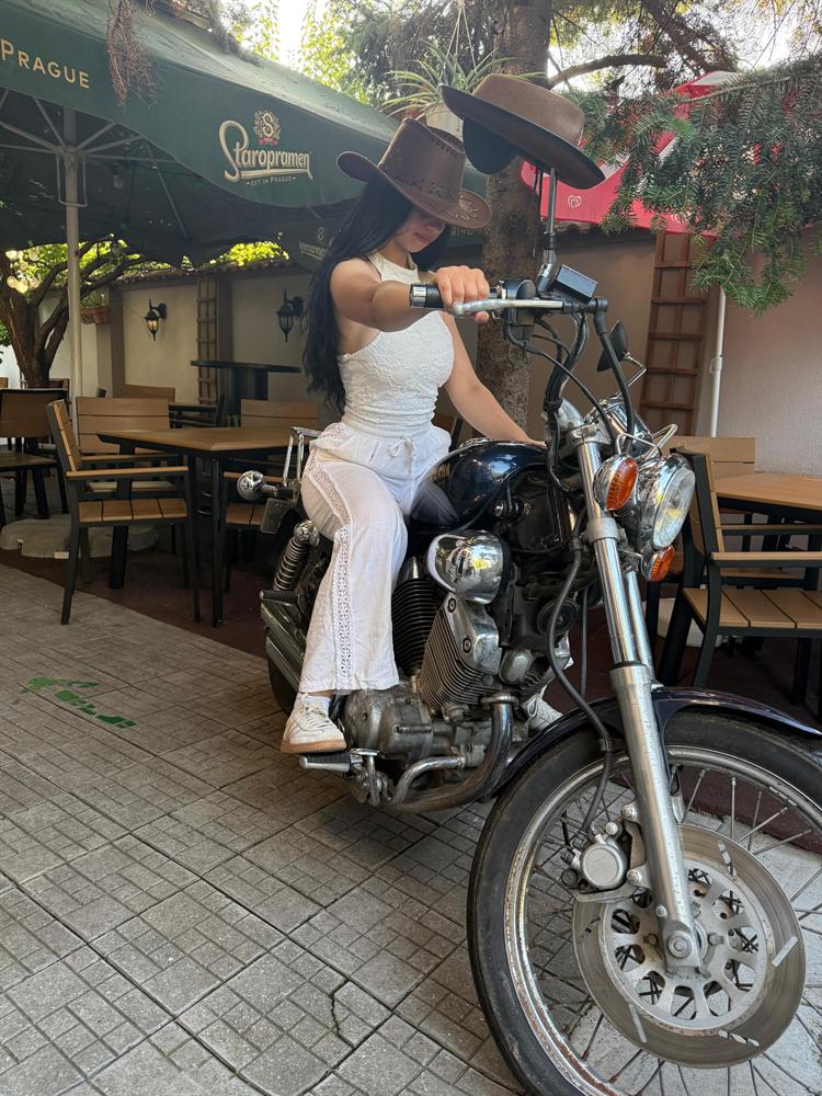 Vizitator cu pălărie de cowboy pe motocicletă